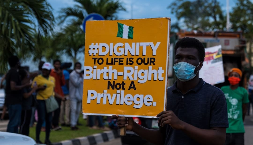 service dog removal — a man holding a sign that says dignity to life is our birth -
